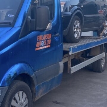 Close-up of the orange Finlayson Auto's Ltd logo on the door of the recovery truck